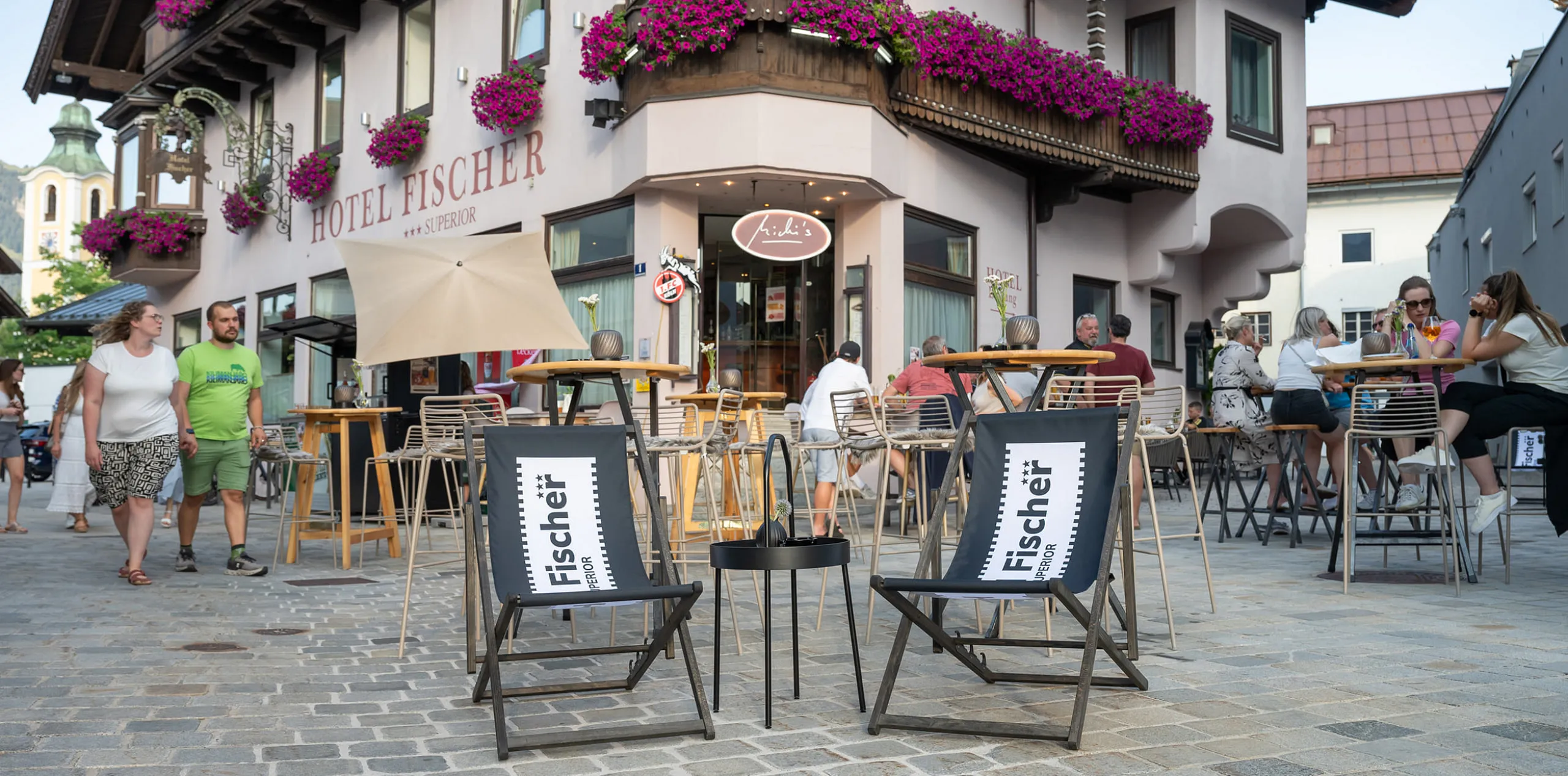 Deck chairs in front of Hotel Fischer with colorful flowers