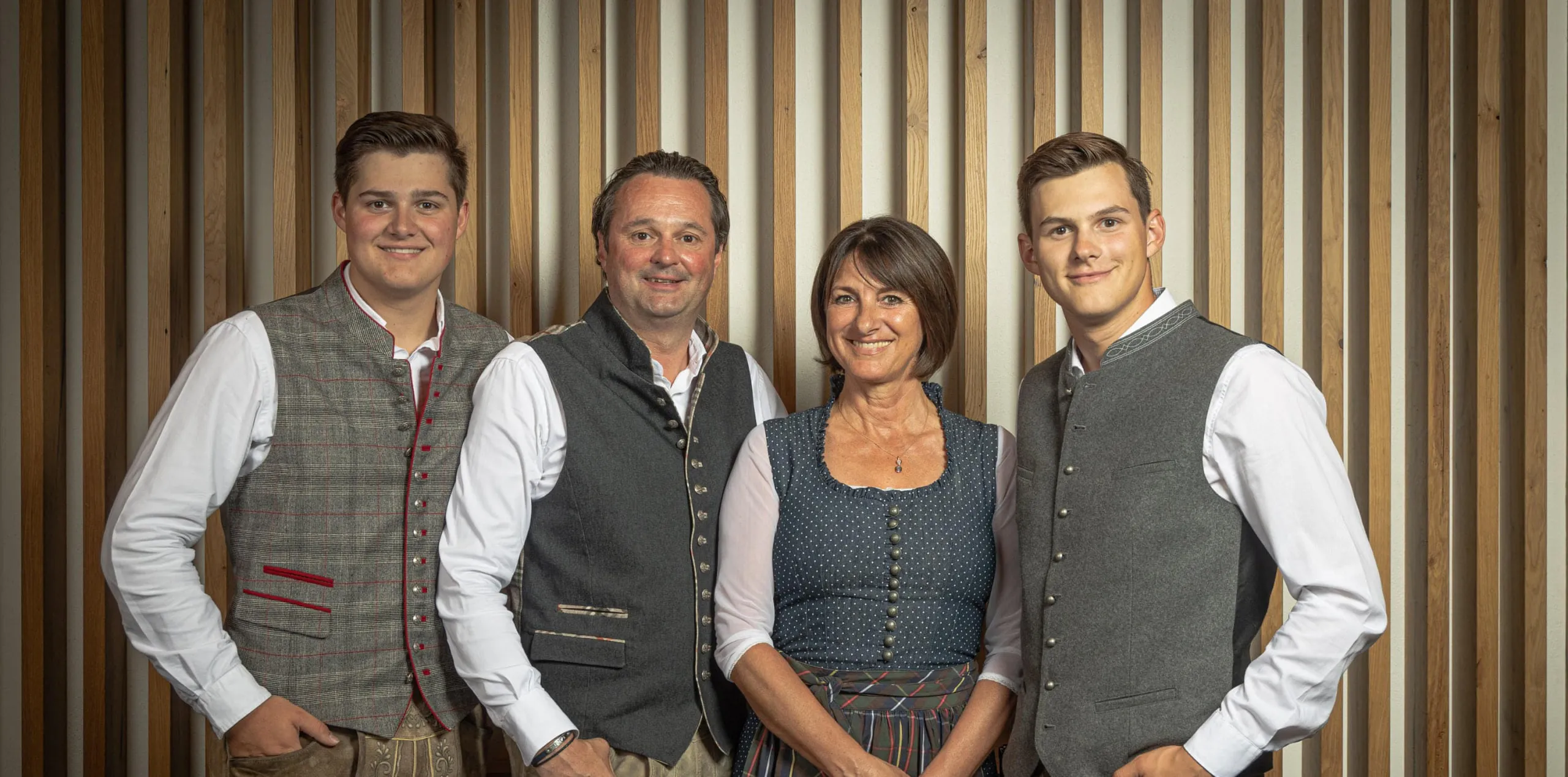 Group of four people posing with wooden backdrop