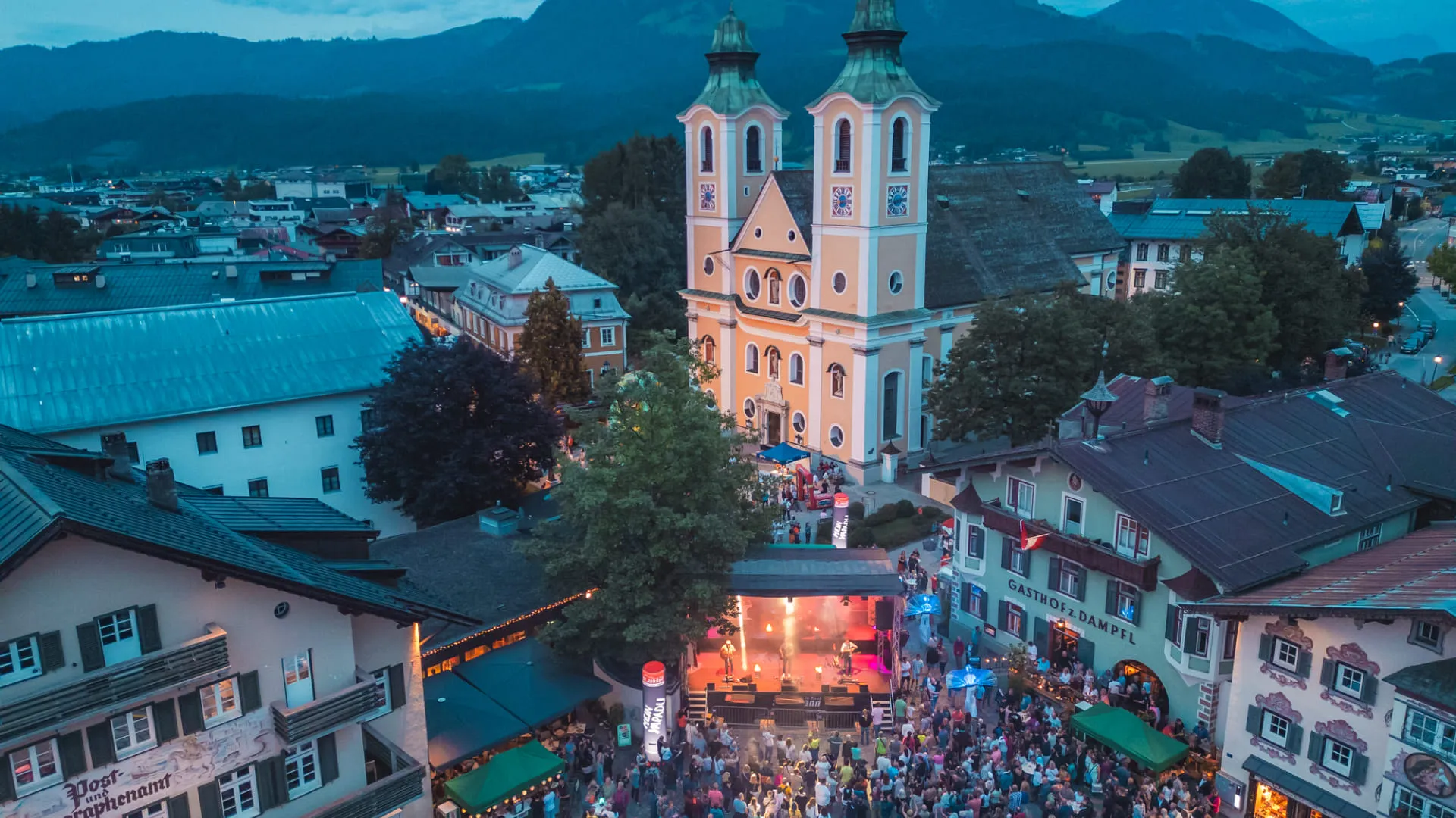 Ortszentrum von St. Johann in Tirol mit der Dekanatskirche am Abend beim Festival Lang & Klang