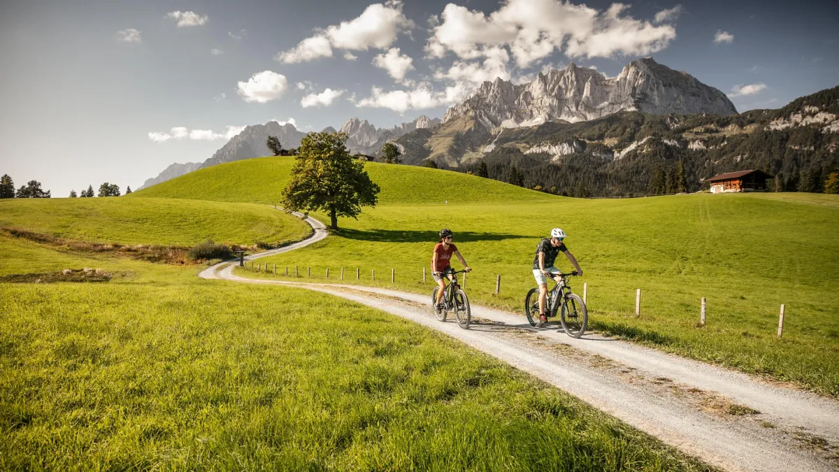 E-Biker auf einem Feldweg bei Oberndorf mit Blick auf den Wilden Kaiser